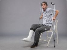 front-view-young-male-with-broken-foot-trying-stand-up-holding-crutches-grey-wall-foot-broken-pain-twist-accident-leg